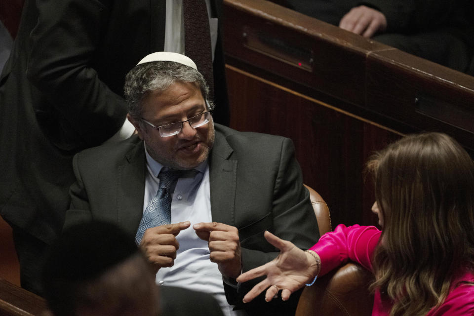 Lawmaker Itamar Ben-Gvir speaks to a colleague during a session of the Knesset, Israel's parliament, ahead of an expected vote on the legal status of Jewish settlers in the occupied West Bank, in Jerusalem, Monday, June 6, 2022. (AP Photo/ Maya Alleruzzo)