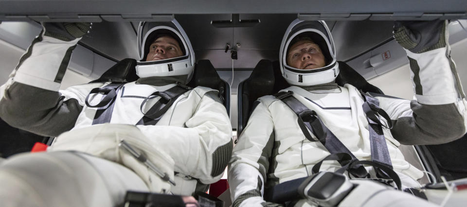 In this August 2018 photo made available by SpaceX, NASA astronauts Doug Hurley and Bob Behnken familiarize themselves with SpaceX's Crew Dragon, the spacecraft that will transport them to the International Space Station as part of NASA's Commercial Crew Program, at the Kennedy Space Center in Cape Canaveral, Fla. (SpaceX via AP)