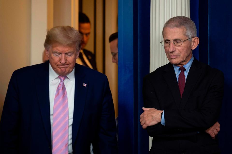 Donald Trump arrives for a White House briefing on the coronavirus pandemic as Anthony Fauci looks on: AFP via Getty Images
