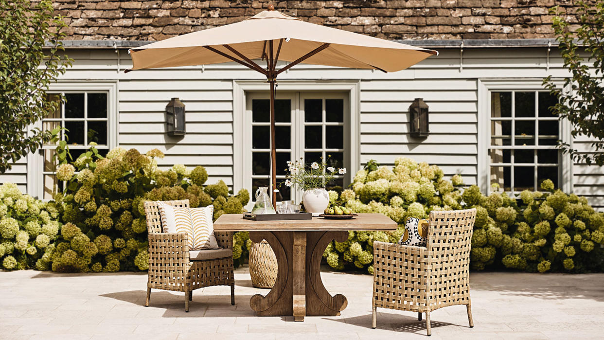  patio table, chairs and umbrella on a patio by a pool 