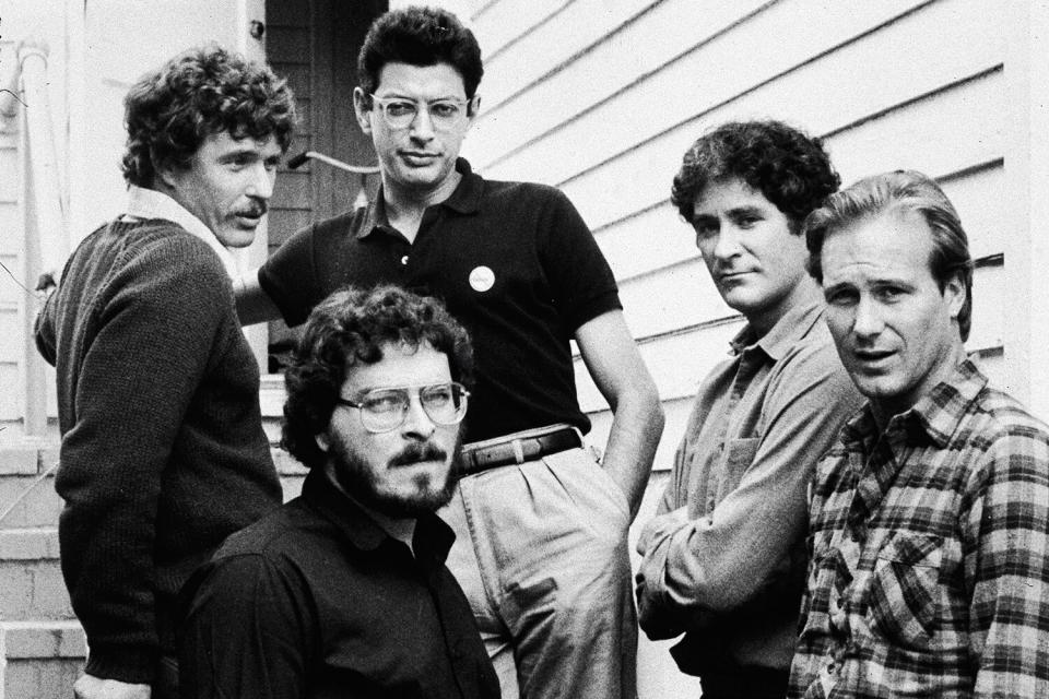 Lawrence Kasdan (front) stands with the male cast of his film, 'The Big Chill,' on location, 1983. L-R: actors Tom Berenger, Jeff Goldblum, Kevin Kline and William Hurt.