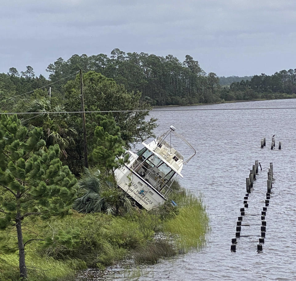 Boat washed up on the shoreline of Bayou Portage in Pass Christian, Miss. from the effects of Hurricane Ida on Monday, Aug. 30, 2021. (Hunter Dawkins/The Gazebo Gazette via AP)/The Gazebo Gazette via AP)