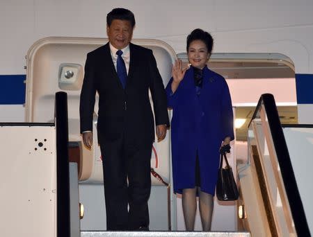 Chinese President Xi Jinping and his wife Peng Liyuan arrive for a a four-day state visit at London's Heathrow Airport, October 19, 2015. REUTERS/Toby Melville