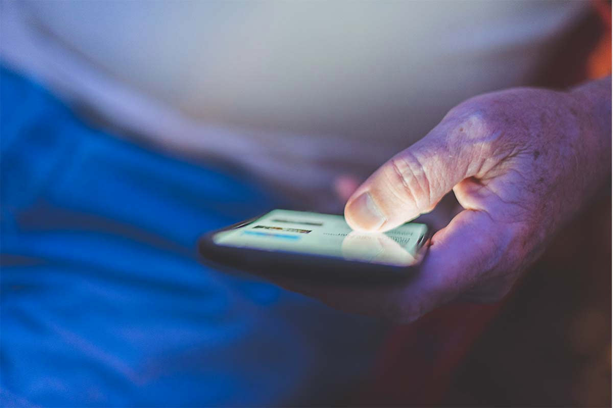 An adult man talking to her friends through a chat application on her smartphone. Chatbots are being used by a few people to virtually recreate deceased loved ones.