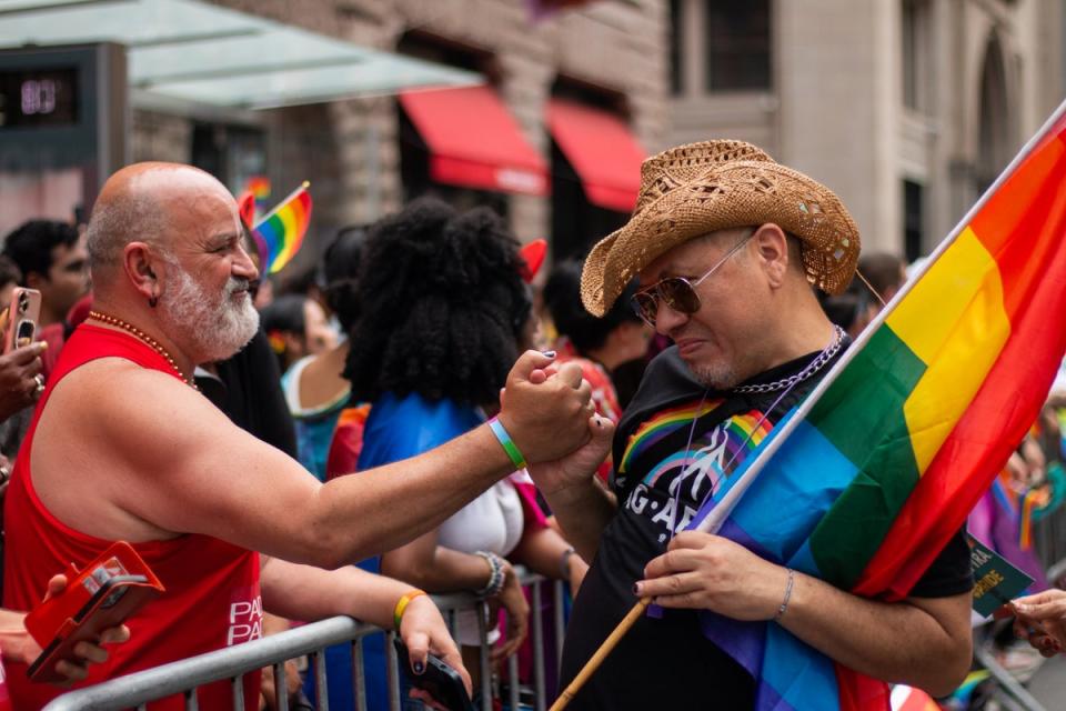 A Pride March attendee and marcher hold hands in New York City (Ariana Baio)