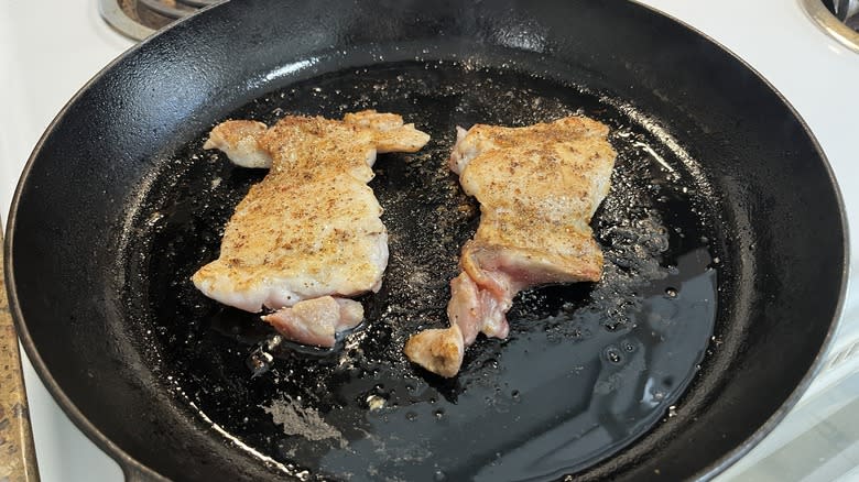 cooking chicken thighs in a frying pan