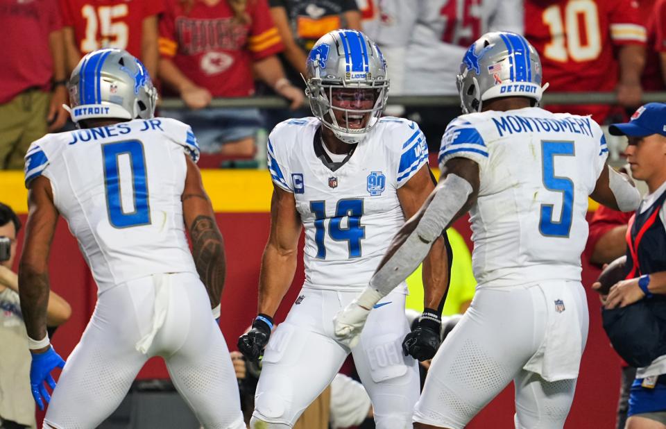 Detroit Lions wide receiver Amon-Ra St. Brown (14) celebrates with teammates Marvin Jones Jr. (0) and David Montgomery (5) after scoring a touchdown against the Kansas City Chiefs.