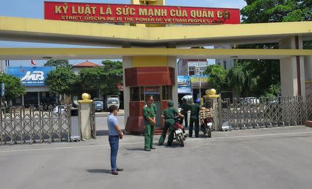 Military soldiers stand guard in front of the headquarters of the Division 308 special military force in Xuan Mai town, outside Hanoi July 10, 2015. REUTERS/Greg Torode -