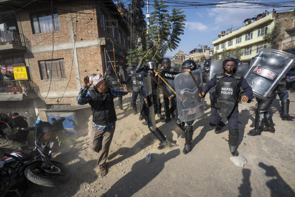 Policemen baton charge protesters during a rally demanding a restoration of Nepal's monarchy in Kathmandu, Nepal, Thursday, Nov. 23, 2023. Riot police used batons and tear gas to halt tens of thousands of supporters of Nepal's former king demanding the restoration of the monarchy and the nation's former status as a Hindu state. Weeks of street protests in 2006 forced then King Gyanendra to abandon his authoritarian rule and introduce democracy. (AP Photo/Niranjan Shrestha)