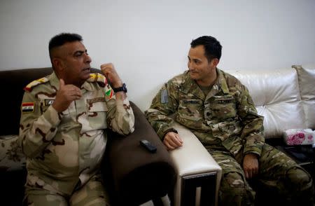 U.S. Army Lieutenant Colonel James Browning (R), the partnered advisor to the Iraqi 9th Armoured Division and commander of Taskforce Fury, listens to Lieutenant General Qassem al-Maliki, commander of the Iraqi army's Ninth Armoured Division at a military base southwest of Mosul, Iraq April 28, 2017. REUTERS/Suhaib Salem