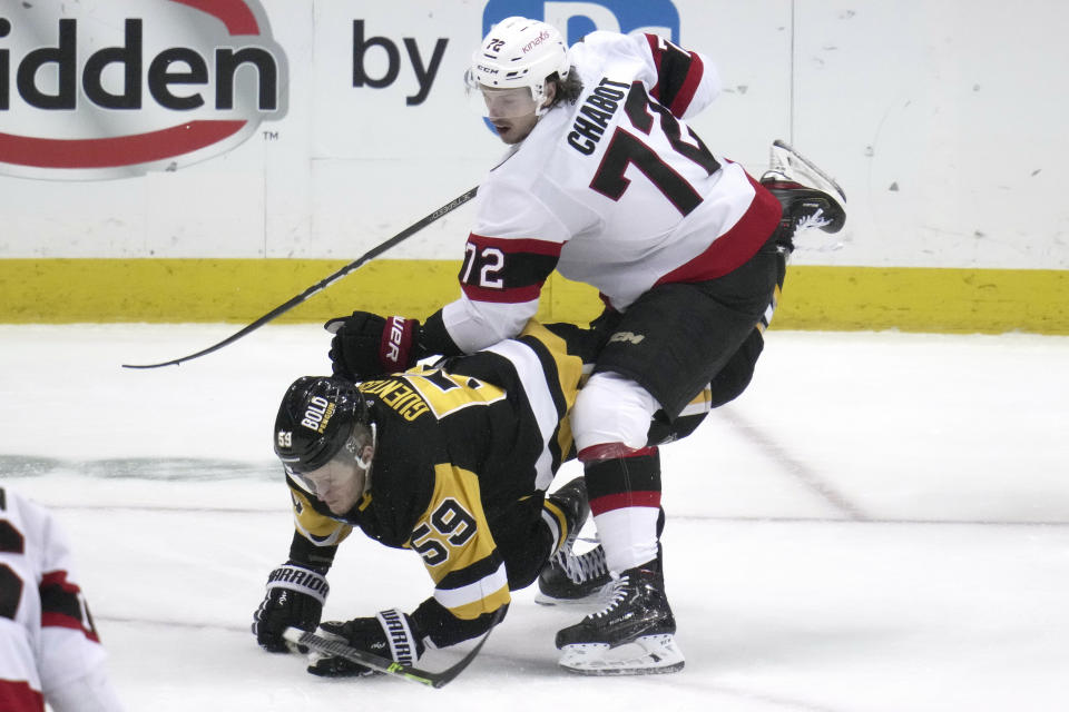 Pittsburgh Penguins' Jake Guentzel (59) is upended by Ottawa Senators' Thomas Chabot during the first period of an NHL hockey game in Pittsburgh, Monday, March 20, 2023. (AP Photo/Gene J. Puskar)