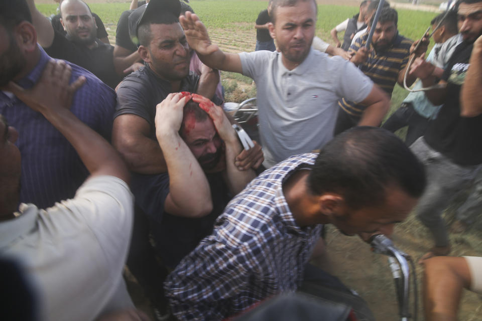 Palestinians transport a captured Israeli civilian, center, from Kibbutz Kfar Azza into the Gaza Strip on Saturday, Oct. 7, 2023. The militant Hamas rulers of the Gaza Strip carried out an unprecedented, multi-front attack on Israel at daybreak Saturday, firing thousands of rockets as dozens of Hamas fighters infiltrated the heavily fortified border in several locations by air, land, and sea and catching the country off-guard on a major holiday. (AP Photo/Hatem Ali)