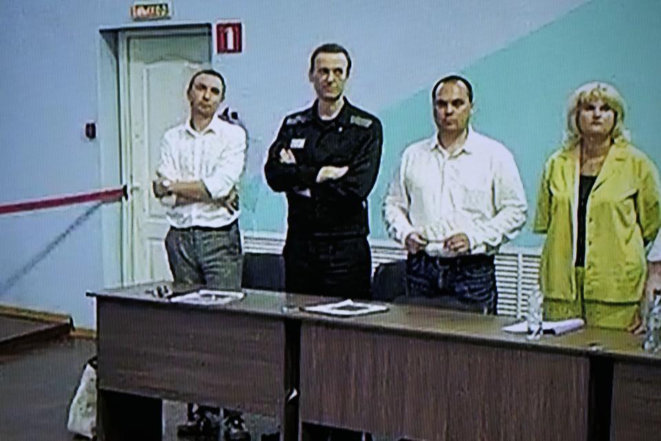 FILE - Russian opposition leader Alexei Navalny, 2nd left, and his lawyers Alexander Fedulov, left, Olga Mikhailova, right, and Vadim Kobzev, second right, are seen on a TV screen standing among his lawyers, as he appears in a video link provided by the Russian Federal Penitentiary Service, during a hearing in the colony, in Melekhovo, Vladimir region, about 260 kilometers (163 miles) northeast of Moscow, Russia, on Friday, Aug. 4, 2023. Most Russian opposition figures are either in prison at home or are in exile abroad. But they vow that they will still put up a fight against President Vladimir Putin as he seeks yet another term in office in an election scheduled for March. (AP Photo, File)