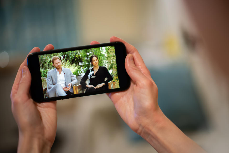 A man watches the Duke and Duchess of Sussex interview with Oprah Winfrey, which is being shown on ITV, on a phone screen in a flat in London. Picture date: Monday March 8, 2021. (Photo by Aaron Chown/PA Images via Getty Images)