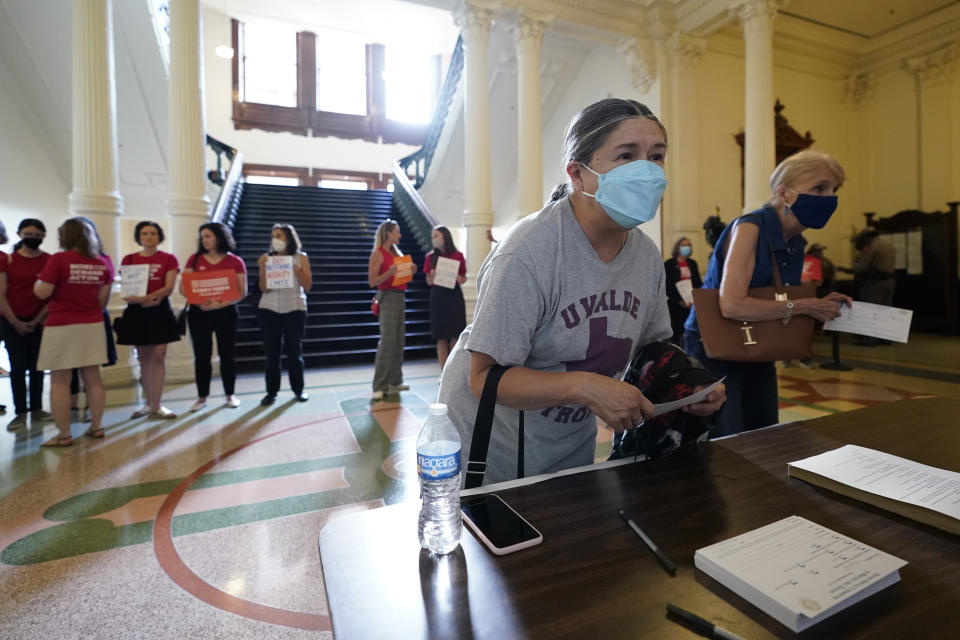 Women with Moms Demand Action gather outside the Texas Senate Chamber as as guests register for the second day of a hearing, Wednesday, June 22, 2022, in Austin, Texas. The hearing is in response to the recent school shooting in Uvalde, Texas, where two teachers and 19 students were killed. (AP Photo/Eric Gay)