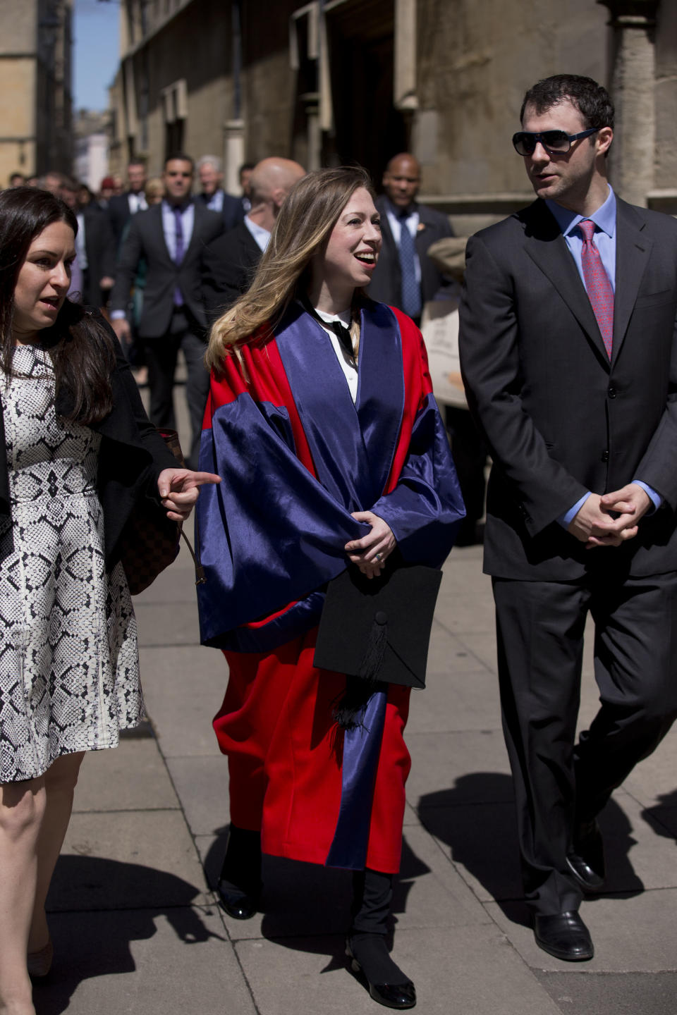 Chelsea Clinton, center, and her husband Marc Mezvinsky, right, walk away as her parents former U.S. President Bill Clinton and former Secretary of State Hillary Rodham Clinton follow behind, after they all attended Chelsea's Oxford University graduation ceremony at the Sheldonian Theatre in Oxford, England, Saturday, May 10, 2014. Chelsea Clinton received her doctorate degree in international relations on Saturday from the prestigious British university. Her father was a Rhodes scholar at Oxford from 1968 to 1970. The graduation ceremony comes as her mother is considering a potential 2016 presidential campaign. (AP Photo/Matt Dunham)