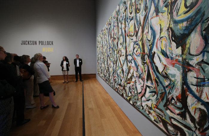 Miembros de medios de comunicación ven la pintura “Mural” de Jackson Pollock de 1943, en el Museo J. Paul Getty en Los Angeles el lunes 10 de marzo de 2014. El óleo sobre lienzo de más de 2,44 metros (8 pies) de alto por casi 6 metros (20 pies) de ancho pasó más de un año oculto en el Museo J. Paul Getty, donde atravesó una vasta restauración. La pintura, propiedad de la Universidad de Iowa, estará en el Museo J. Paul Getty del 11 de marzo al 1 de junio de 2014. (Foto AP/Nick Ut )