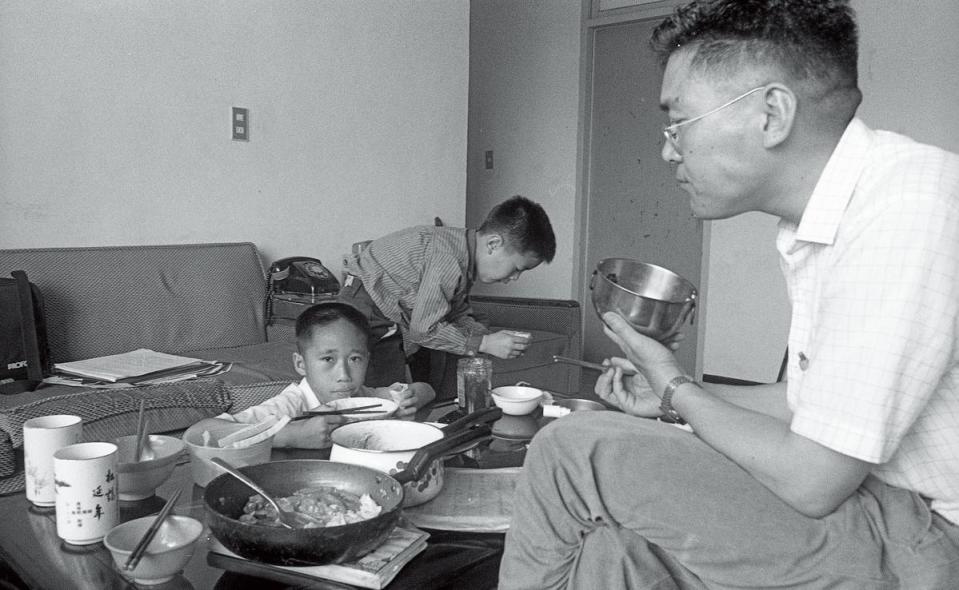 周子飛（左）被戴浙（右）收養初期，和戴浙的親生兒子（中）一同長大。圖為1988年，3人的午餐時刻。（蔡明德攝）