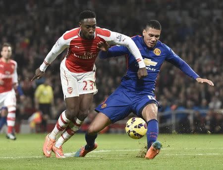 Manchester United's Chris Smalling (R) challenges Arsenal's Danny Welbeck during their English Premier League soccer match at the Emirates Stadium in London November 22, 2014. REUTERS/Toby Melville