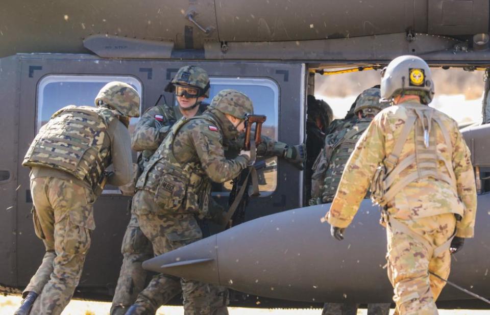 Paratroopers assigned to 1st Brigade Combat Team, 82nd Airborne Division train members of the Polish military on hot loading procedures on an Army Black Hawk helicopter March 22, 2022, in Bircza, Poland.