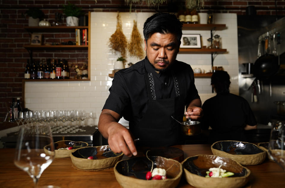 Chef Aaron Verzosa demonstrates plating Tailor Made, a course in which diners disclose their hunger level from five to one, at Filipino American restaurant Archipelago, Wednesday, May 24, 2023, in Seattle. Verzosa is nominated for a 2023 James Beard Award in the Best Chef: Northwest and Pacific category. (AP Photo/Lindsey Wasson)