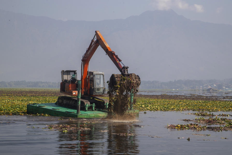 A de-weeding machine removes weeds and lotus lilies at Dal lake in Srinagar, Indian controlled Kashmir, Tuesday, Sept. 14, 2021. Weeds, silt and untreated sewage are increasingly choking the sprawling scenic lake, which dominates the city and draws tens of thousands of tourists each year. (AP Photo/Mukhtar Khan)