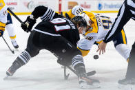 A referee drops the puck for a face-off between New Jersey Devils center Dawson Mercer (91) and Nashville Predators center Ryan O'Reilly (90) during the first period of an NHL hockey game in Newark, N.J., Sunday, April 7, 2024. (AP Photo/Peter K. Afriyie)