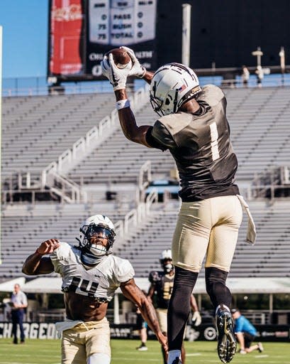 UCF wide receiver Javon Baker (1) leaps to catch a pass with Corey Thornton in coverage.