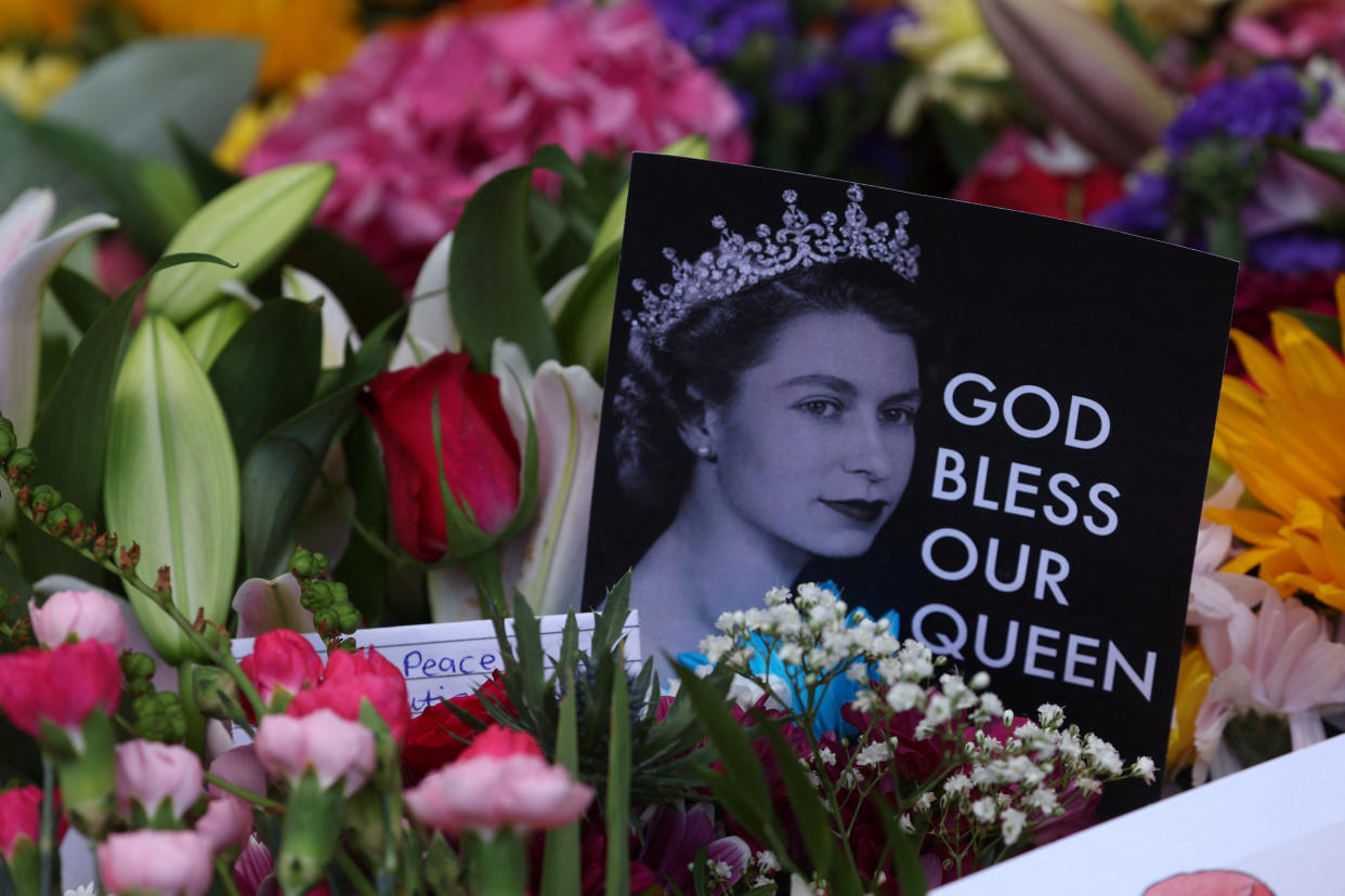 Cards and flowers are laid out on Saturday in honor of the queen