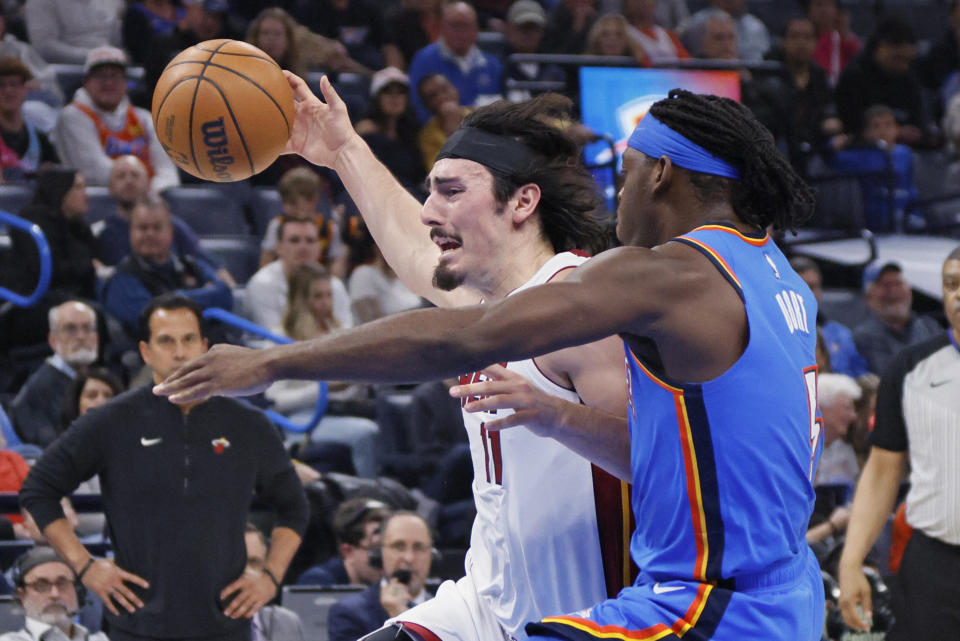 Miami Heat guard Jaime Jaquez Jr., left, drives against Oklahoma City Thunder guard Luguentz Dort, right, during the first half of an NBA basketball game Friday, March 8, 2024, in Oklahoma City. (AP Photo/Nate Billings)