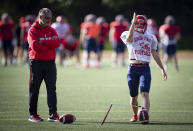 Simon Fraser University football team kicker Kristie Elliott lines up a kick as coach Jerome Erdman watches during team practice in Burnaby, B.C., Tuesday, Sept. 21, 2021. Elliott became the first Canadian woman to play in an NCAA football game. “She’s worked her butt off. Everything she’s gotten she deserves,” said Jerome Erdman, the team’s defensive coordinator. “There’s a lot of pressure on her and she’s handled it very well.” (Darryl Dyck/The Canadian Press via AP)