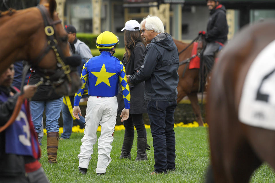 Jockey Drayden Van Dyke, left, talks with trainer Bob Baffert before riding Charlatan in the sixth race at Santa Anita on Saturday, March 14, 2020, in Arcadia, Calif. Charlatan won the horse race. (AP Photo/Mark J. Terrill)