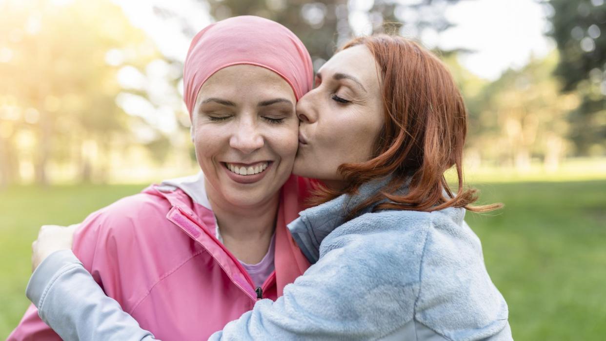 women hugging with closed eyes while kissing the fighter against cancer concept fight against breast cancer 