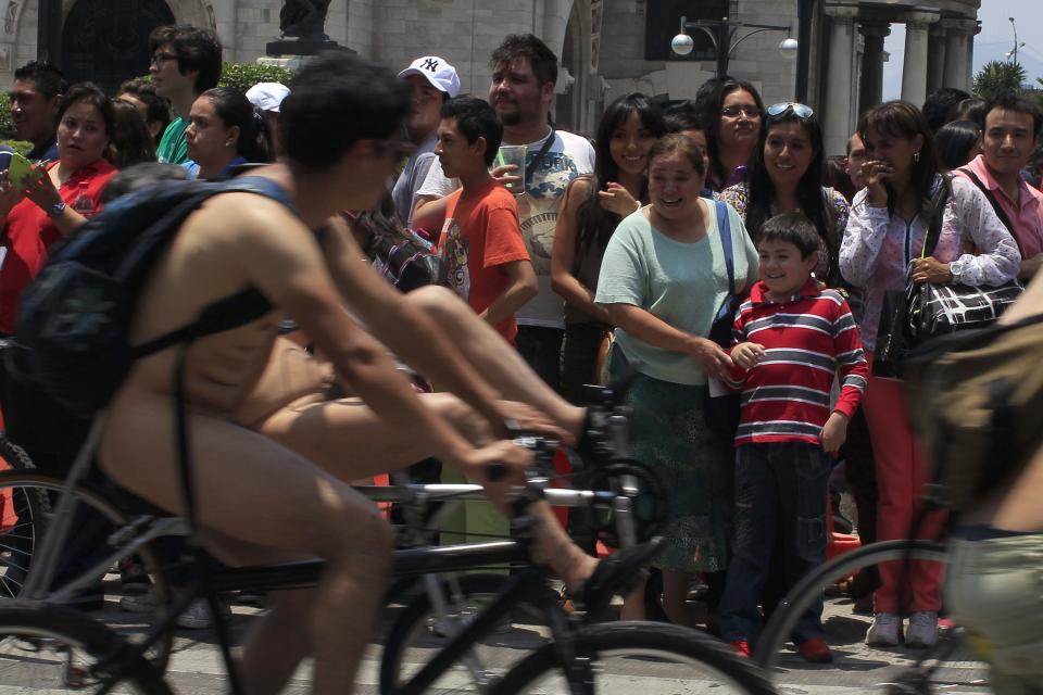 Orang-orang yang menonton menunjukkan reaksi mereka saat para pengendara sepeda melintas di depan mereka tanpa mengenakan pakaian sebagai bagian dari acara World Naked Bike Ride. Pihak penyelenggara mengatakan acara ini ditujukan untuk membela hak-hak para pengendara sepeda agar dapat bersepeda dengan aman di jalanan. REUTERS/Tomas Bravo (MEXICO - Tags: SOCIETY SPORT CYCLING TPX IMAGES OF THE DAY)