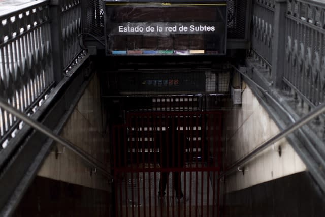 An employee stands in the closed entrance of the Buenos Aires underground railway system during the blackout 