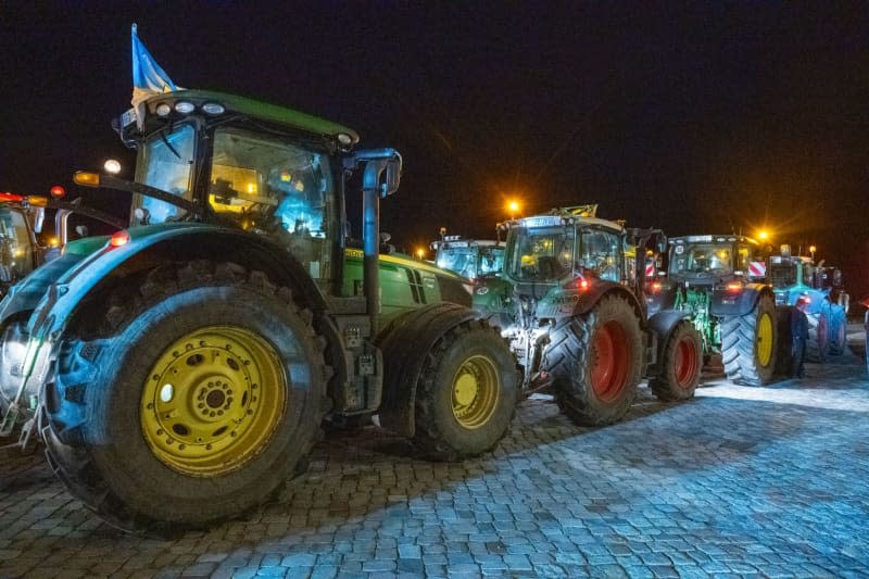 Tractors stand on the harbor island near the Ozeaneum. In Mecklenburg-Western Pomerania, farmers have once again vented their displeasure at the traffic light's cost-cutting plans with protest actions. Stefan Sauer/dpa