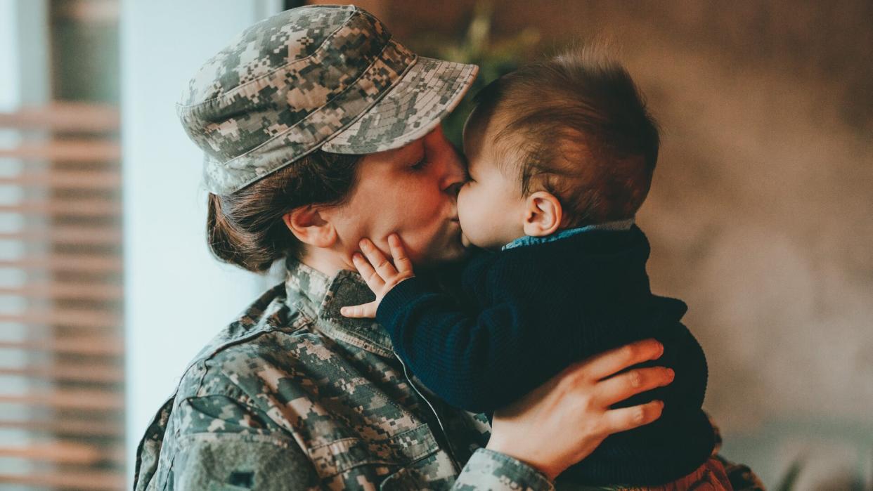 Sad military soldier says goodbye to her son.