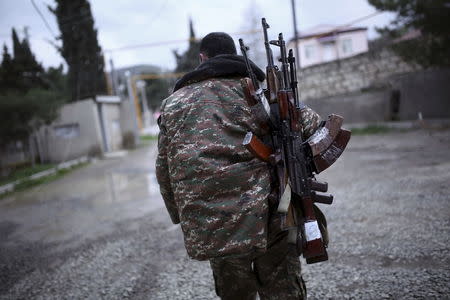 A soldier of the self-defense army of Nagorno-Karabakh carries weapons in Martakert province, which according to Armenian media was affected by clashes over the breakaway Nagorno-Karabakh region, April 4, 2016. REUTERS/Vahan Stepanyan/PAN Photo