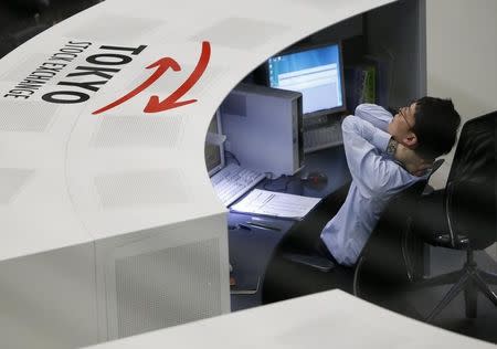 An employee of the Tokyo Stock Exchange (TSE) stretches at the bourse at the TSE in Tokyo April 11, 2014. REUTERS/Issei Kato