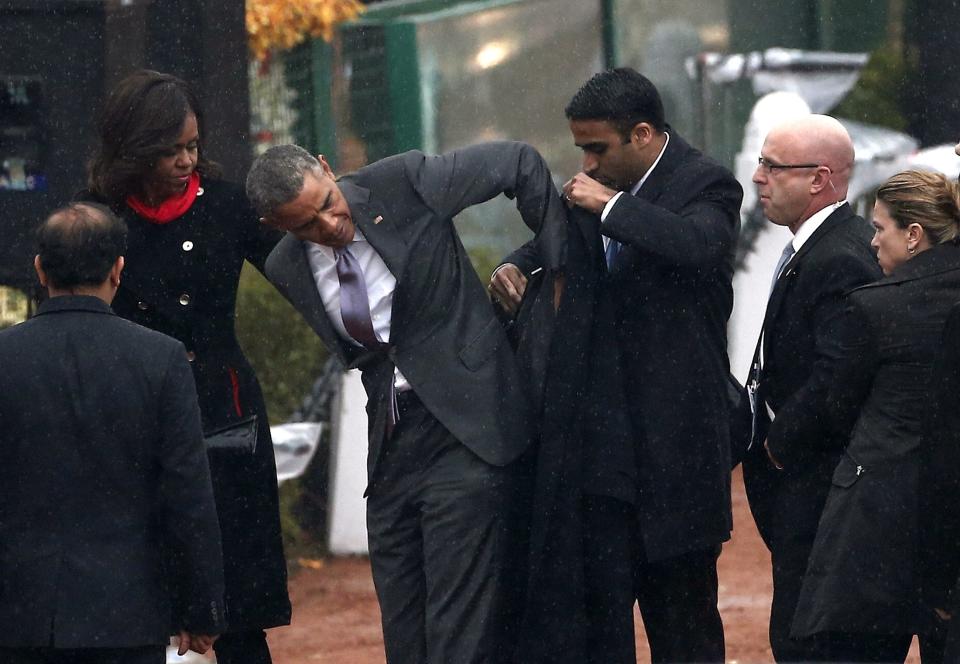 U.S. President Obama puts on a coat as first lady Michelle upon their arrival to attend the Republic Day parade in New Delhi