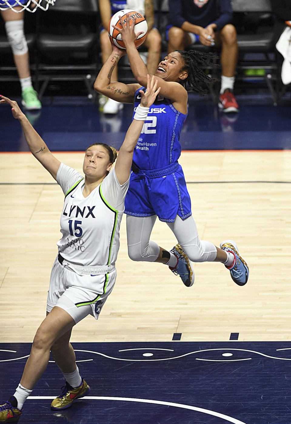 Connecticut Sun's Tyasha Harris (52) puts up a basket over Minnesota Lynx's Rachel Banham (15) during a WNBA basketball game, Sunday, Sept. 17, 2023, at Mohegan Sun Arena in Uncasville, Conn. (Sarah Gordon/The Day via AP)