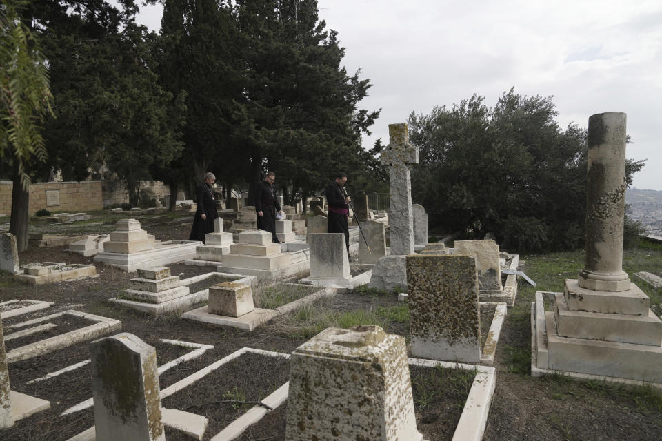 Hosam Naoum, a Palestinian Anglican bishop, walks with other clergy where vandals desecrated more than 30 graves at a historic Protestant Cemetery on Jerusalem's Mount Zion in Jerusalem, Wednesday, Jan. 4, 2023. Israel's foreign ministry called the attack an "immoral act" and "an affront to religion." Police officers were sent to investigate the profanation. (AP Photo/ Mahmoud Illean)