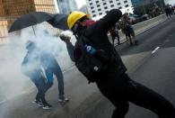 A demonstrator throws a tear gas canister during a protest in Hong Kong