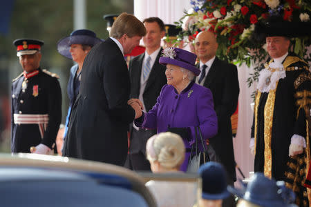 Britain's Queen Elizabeth greets King Willem-Alexander of the Netherlands during a ceremonial welcome at the start of a state visit at Horse Guards Parade, in London, Britain October 23, 2018. Christopher Furlong/Pool via REUTERS