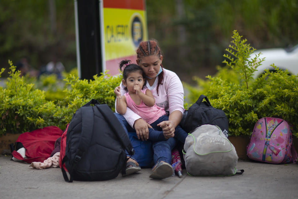 Migrants hoping to reach the distant U.S. border rest on the side of a highway, in Jocotan, Guatemala, Saturday, Jan. 16, 2021. Honduran migrants pushed their way into Guatemala Friday night without registering, a portion of a larger migrant caravan that had left the Honduran city of San Pedro Sula before dawn, Guatemalan authorities said. (AP Photo/Sandra Sebastian)