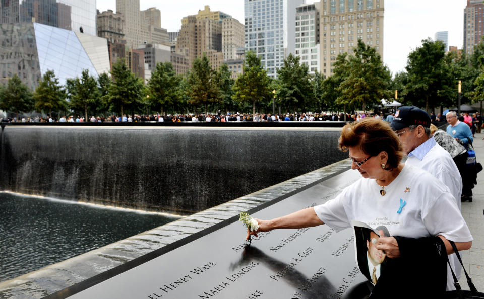 NEW YORK, NY - SEPTEMBER 11: Maria Cioccone, of New York, places a flower in the inscribed name of her son Alex along the edge of the North Pool Memorial site during observances at the site of the World Trade Center on September 11, 2014 in New York City. This year marks the 13th anniversary of the September 11th terrorist attacks that killed nearly 3,000 people at the World Trade Center, Pentagon and on Flight 93. (Photo by Justin Lane-Pool/Getty Images)