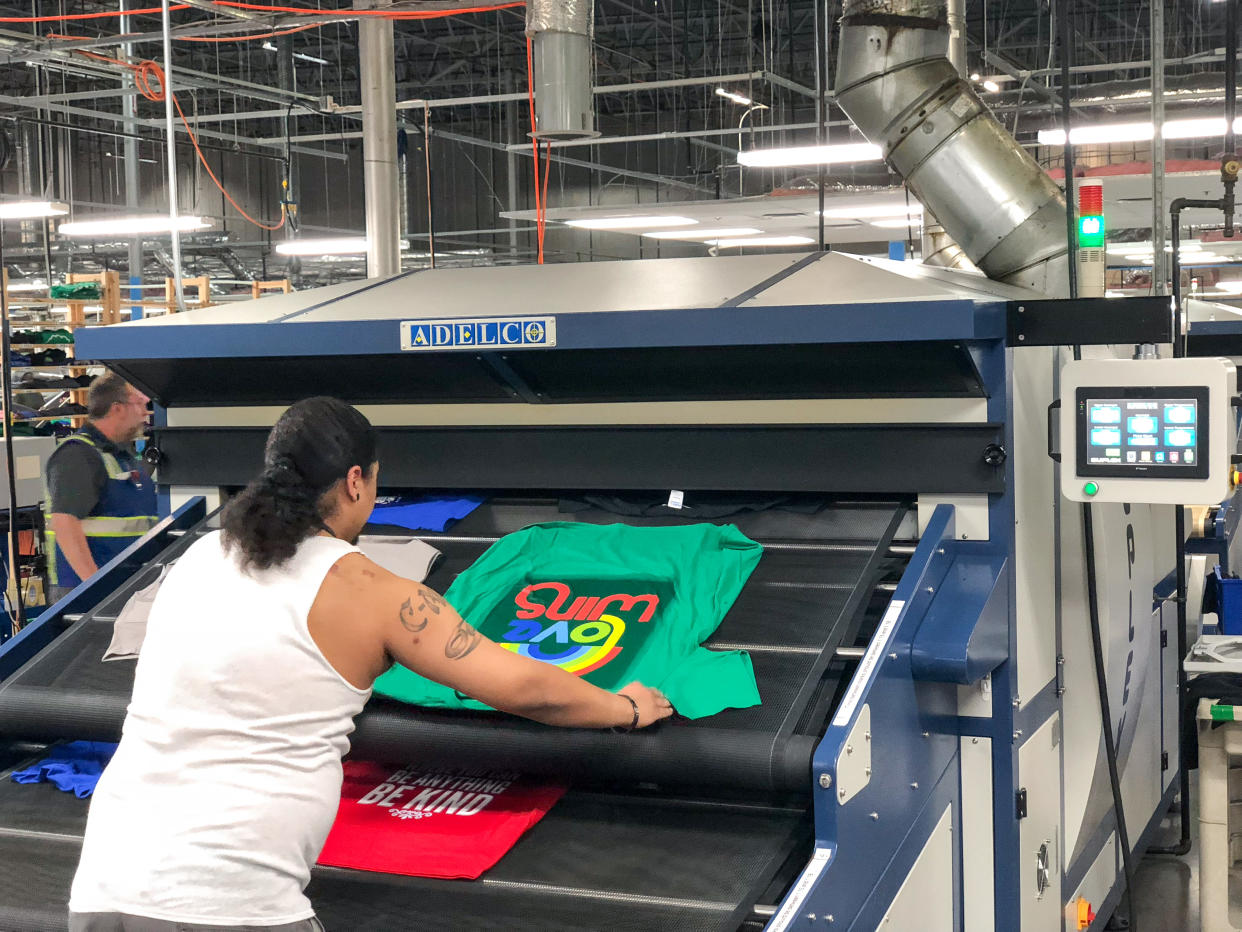 A worker prints T-shirt in an Amazon facility for the Merch by Amazon program. (Credit: Amazon)