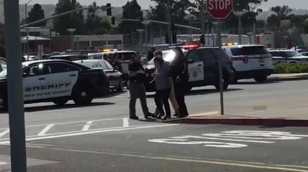 Video grab of a police officer directing pedestrians near the scene of a shooting at the Tanforan Mall shopping center in San Bruno, San Francisco