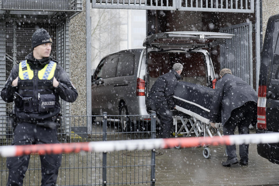 Corpses are carried out of a Jehovah's Witness building and loaded into hearses in Hamburg, Germany Friday, March 10, 2023. Shots were fired inside the building used by Jehovah's Witnesses in the northern German city of Hamburg on Thursday evening, with multiple people killed and wounded, police said. (AP Photo/Markus Schreiber)