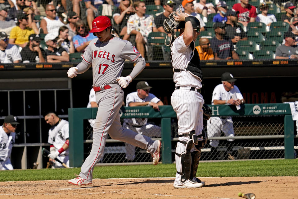 Los Angeles Angels' Shohei Ohtani, of Japan, left, scores on a one-run single by Jared Walsh as Chicago White Sox catcher Zack Collins looks to the field during the fifth inning of a baseball game in Chicago, Thursday, Sept. 16, 2021. (AP Photo/Nam Y. Huh)